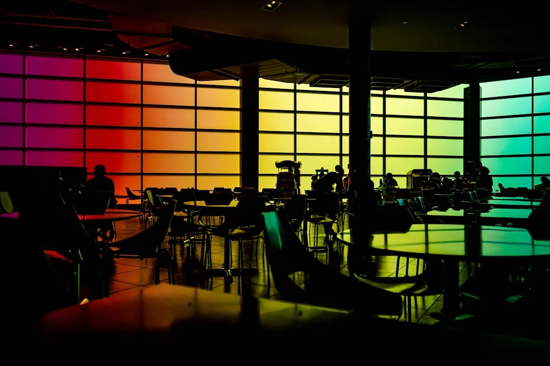 Rainbow color temperature gradient from warm red to cool teal across large window panels in a modern interior space