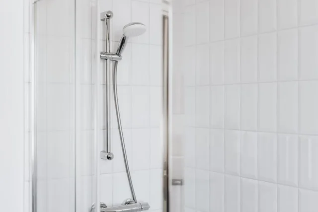 Chrome handheld shower head on sliding rail bar in