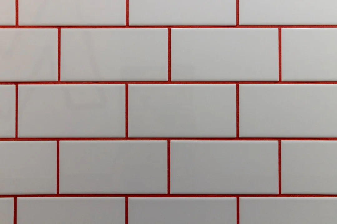 White subway tiles with bold red grout showing hig