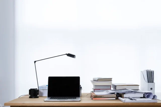 Desk lamp providing task lighting on a wooden work