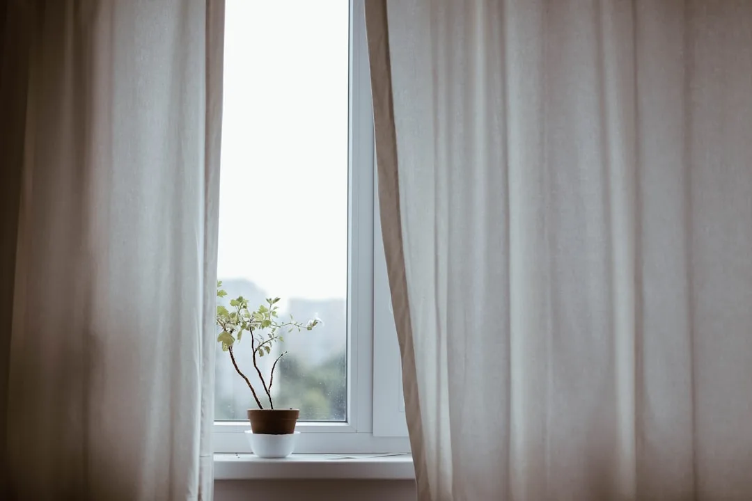 White linen curtains hanging floor-length beside a