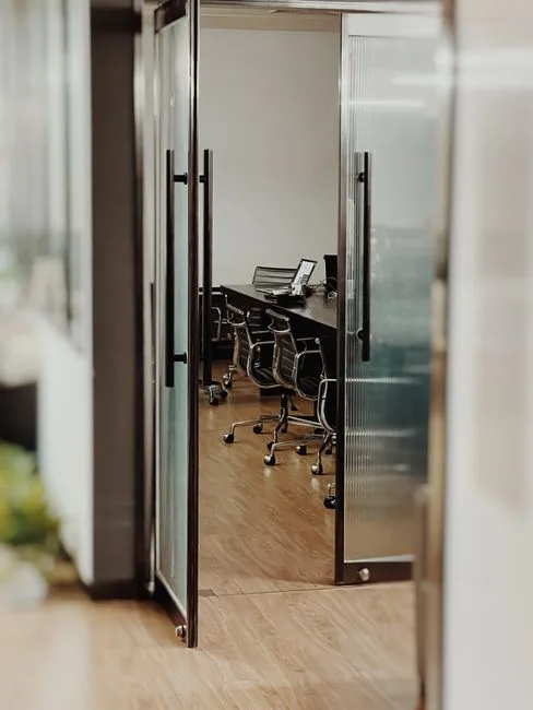 Glass-walled conference room with ergonomic office