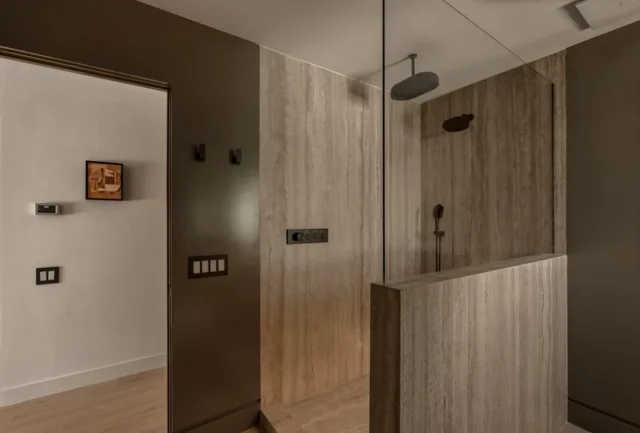 Modern bathroom with travertine tile focal wall in