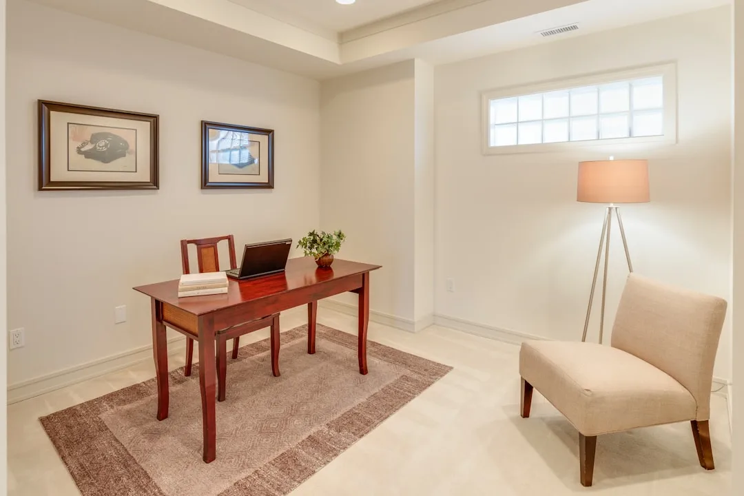 Neutral beige home office with mahogany desk, lapt